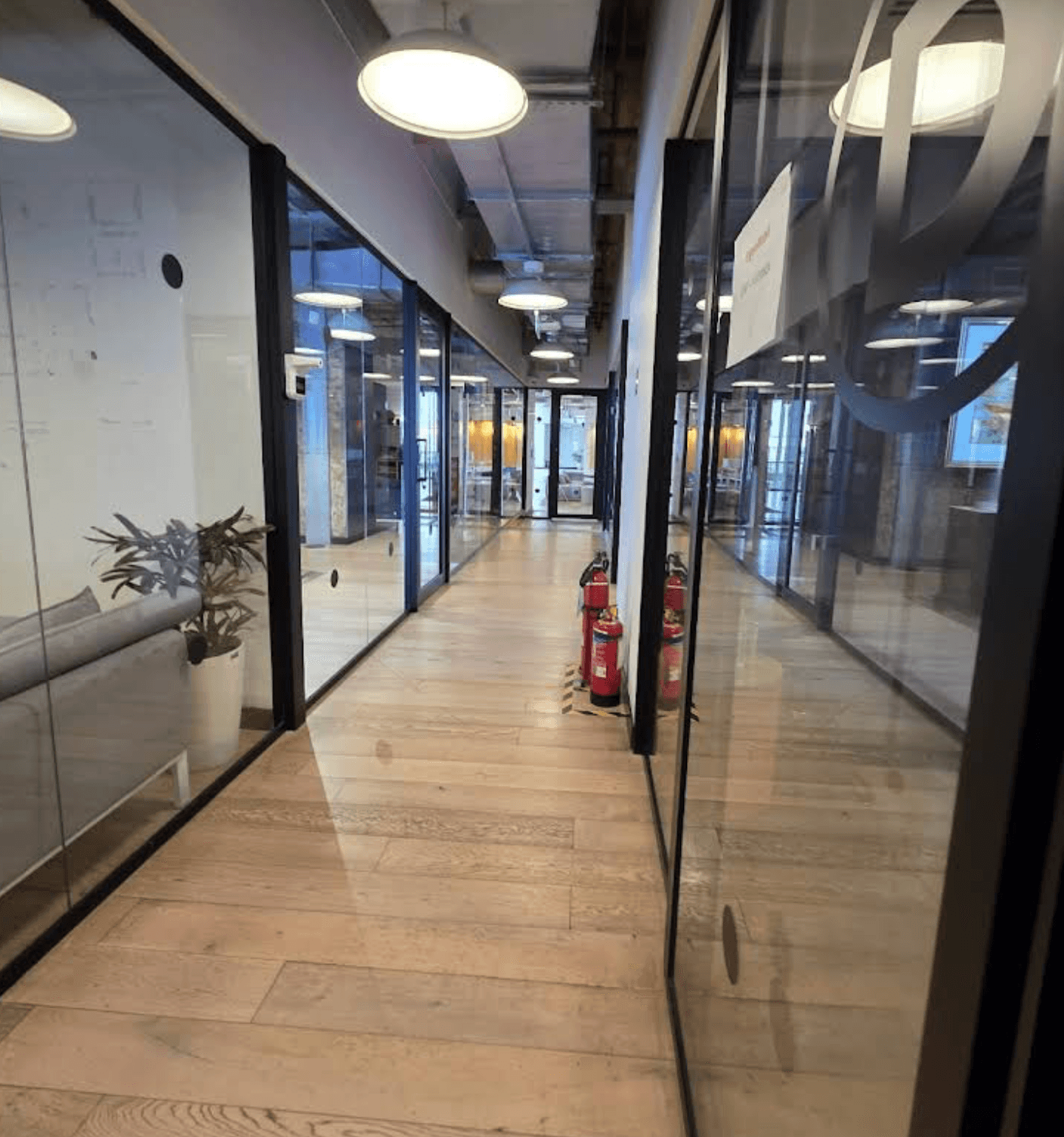 Glass-walled corridor inside the Wework Forum DLF Cyber City office